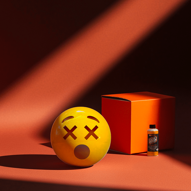 Hands holding a red orb with intricate, patterned artwork depicting a figure with sunglasses.