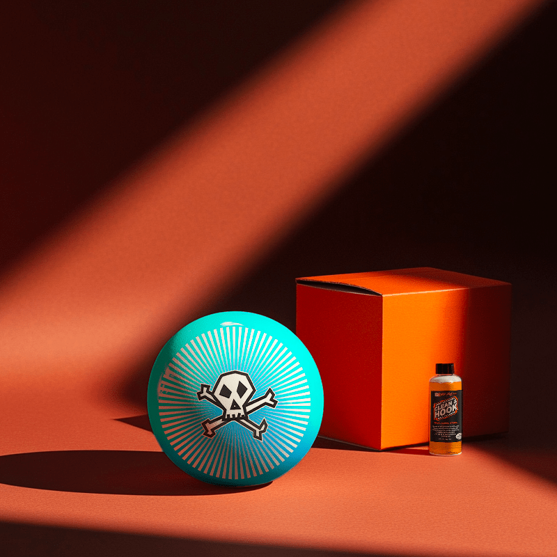 Hands holding a red orb with intricate, patterned artwork depicting a figure with sunglasses.