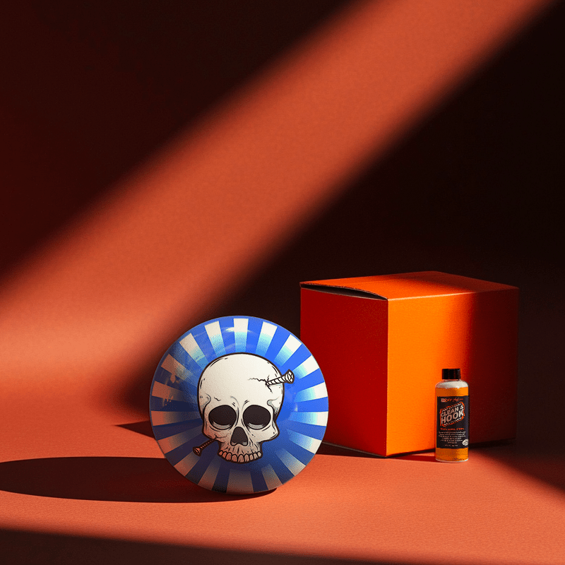 Hands holding a red orb with intricate, patterned artwork depicting a figure with sunglasses.