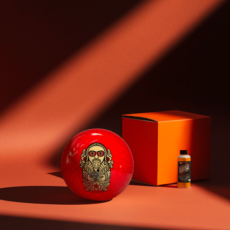 Hands holding a red orb with intricate, patterned artwork depicting a figure with sunglasses.