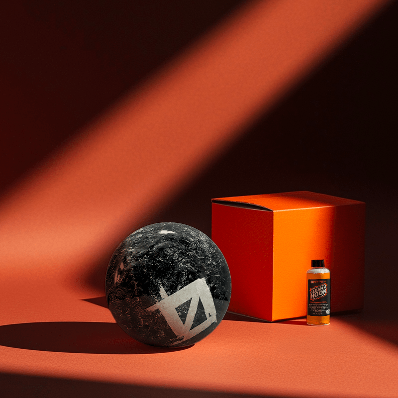 Hands holding a red orb with intricate, patterned artwork depicting a figure with sunglasses.