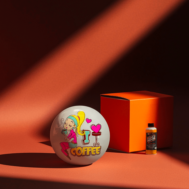 Hands holding a red orb with intricate, patterned artwork depicting a figure with sunglasses.