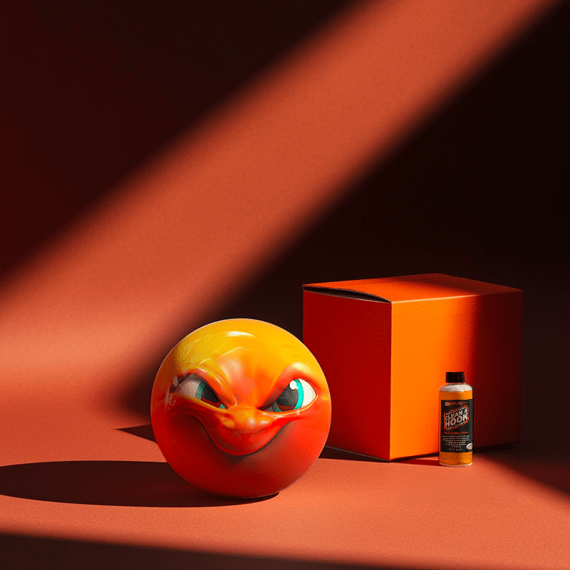 Hands holding a red orb with intricate, patterned artwork depicting a figure with sunglasses.