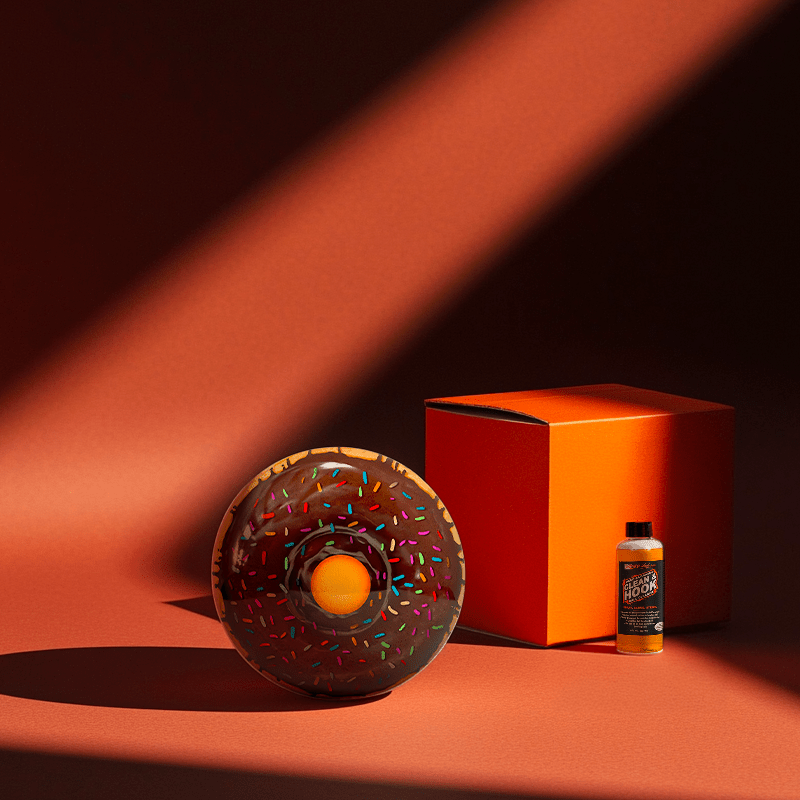 Hands holding a red orb with intricate, patterned artwork depicting a figure with sunglasses.