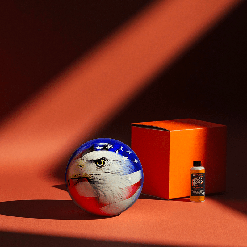 Hands holding a red orb with intricate, patterned artwork depicting a figure with sunglasses.