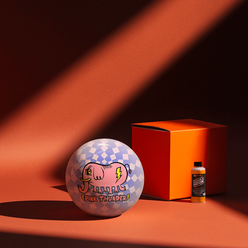 Hands holding a red orb with intricate, patterned artwork depicting a figure with sunglasses.