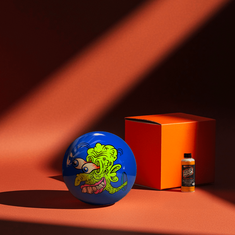 Hands holding a red orb with intricate, patterned artwork depicting a figure with sunglasses.