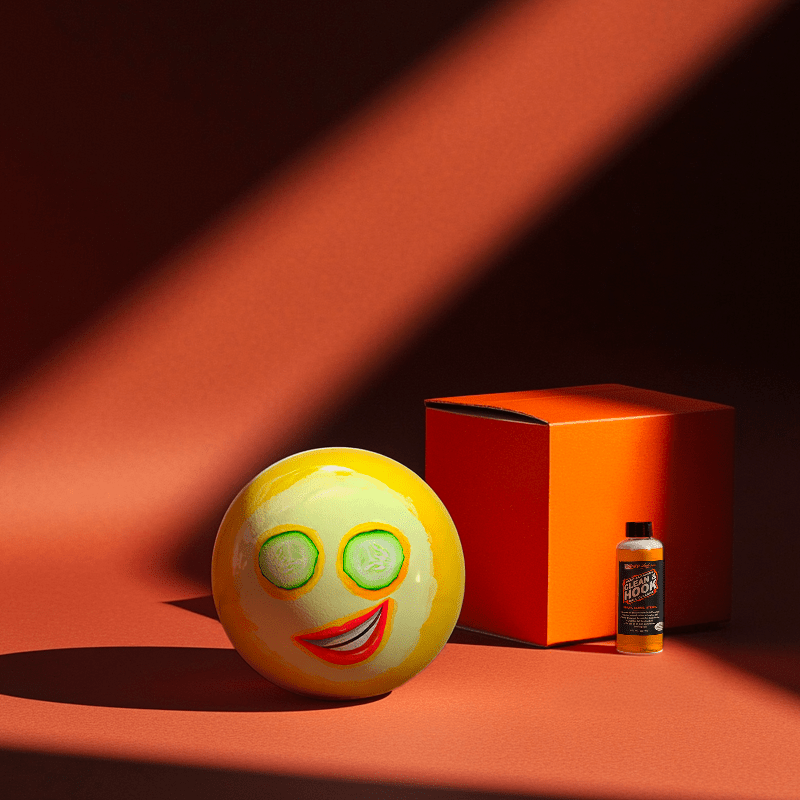 Hands holding a red orb with intricate, patterned artwork depicting a figure with sunglasses.