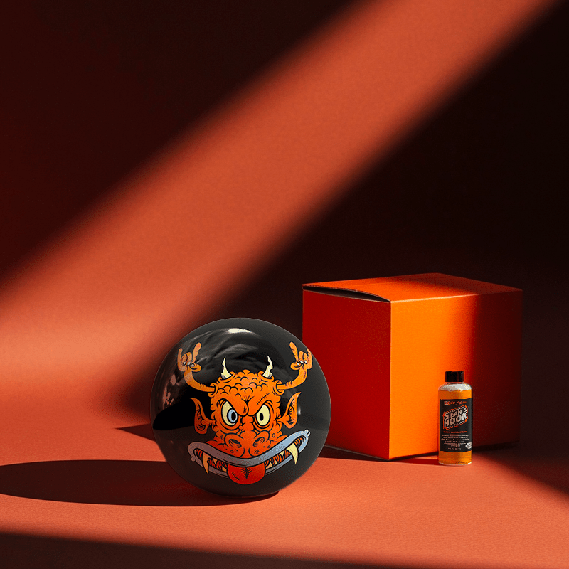 Hands holding a red orb with intricate, patterned artwork depicting a figure with sunglasses.