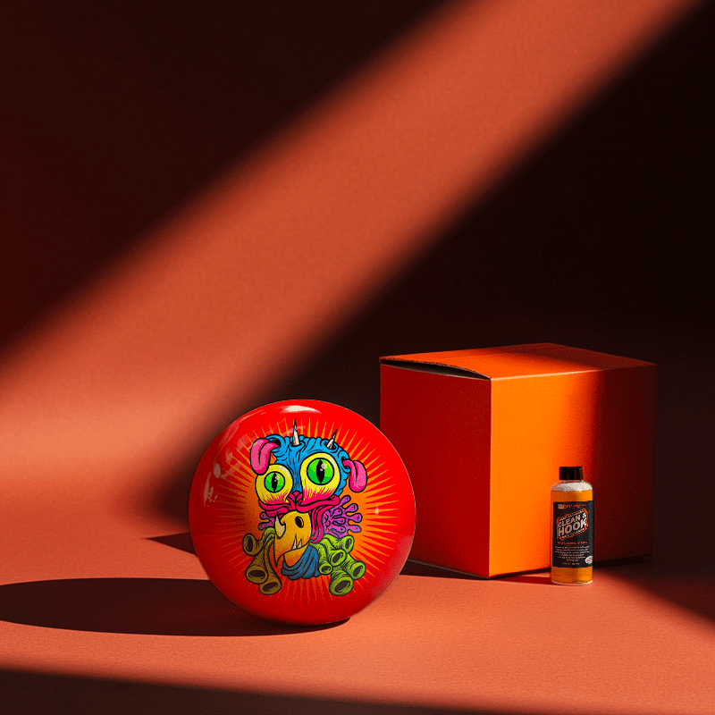 Hands holding a red orb with intricate, patterned artwork depicting a figure with sunglasses.