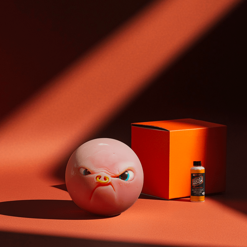 Hands holding a red orb with intricate, patterned artwork depicting a figure with sunglasses.