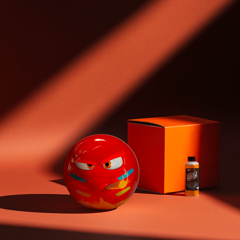 Hands holding a red orb with intricate, patterned artwork depicting a figure with sunglasses.