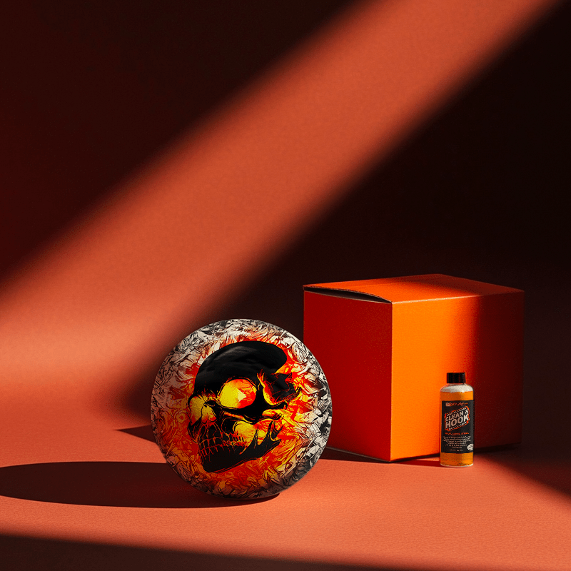 Hands holding a red orb with intricate, patterned artwork depicting a figure with sunglasses.