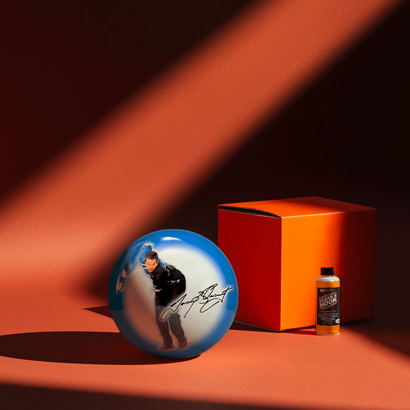 Hands holding a red orb with intricate, patterned artwork depicting a figure with sunglasses.