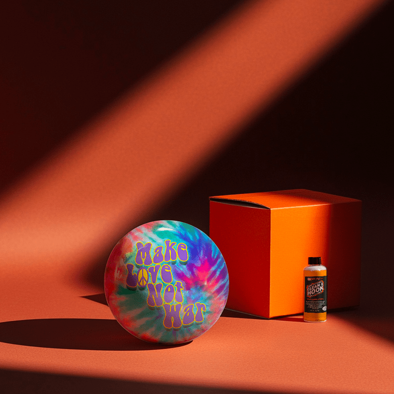 Hands holding a red orb with intricate, patterned artwork depicting a figure with sunglasses.