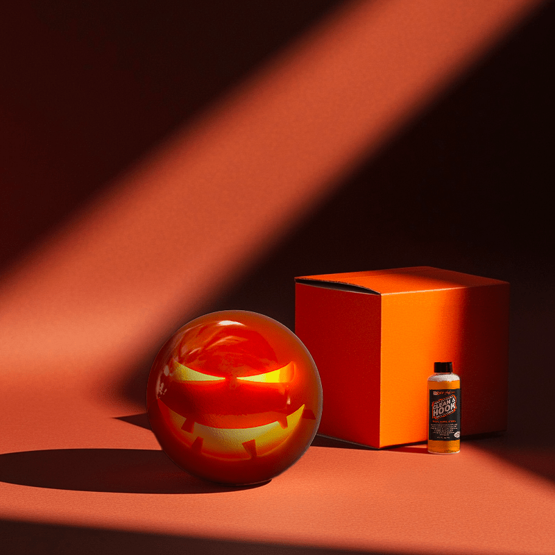 Hands holding a red orb with intricate, patterned artwork depicting a figure with sunglasses.