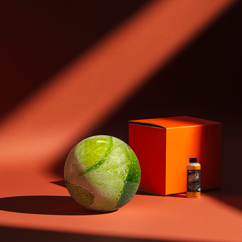 Hands holding a red orb with intricate, patterned artwork depicting a figure with sunglasses.