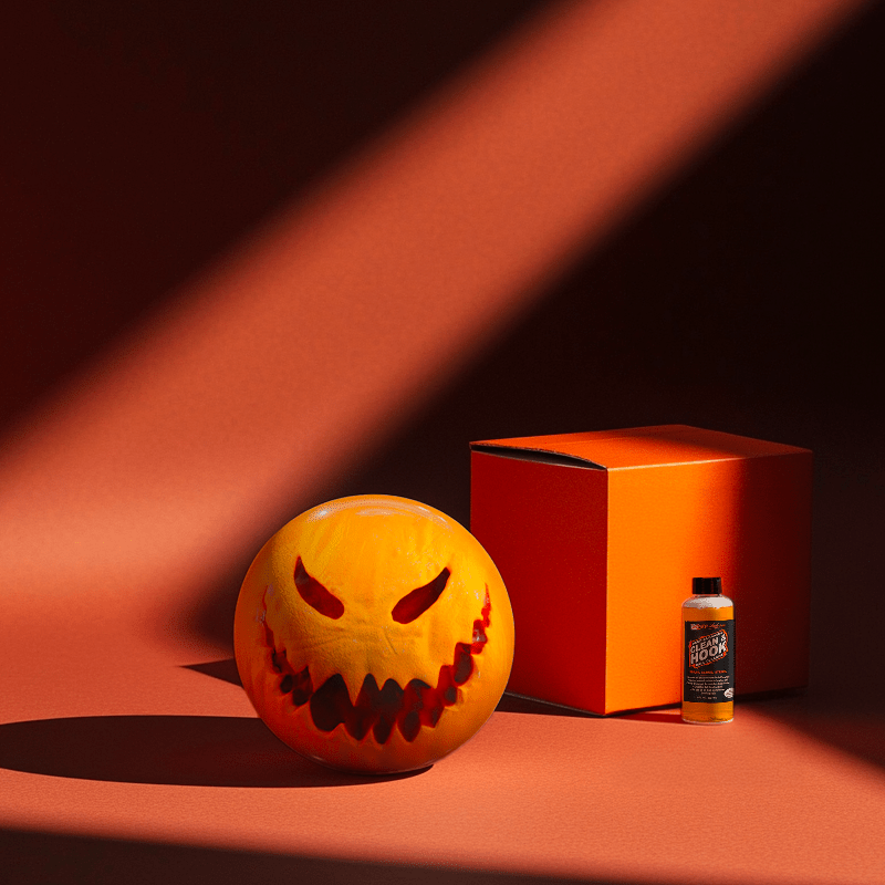 Hands holding a red orb with intricate, patterned artwork depicting a figure with sunglasses.