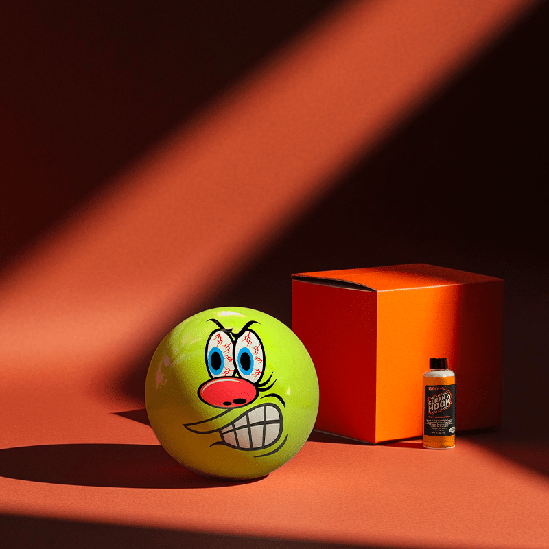 Hands holding a red orb with intricate, patterned artwork depicting a figure with sunglasses.