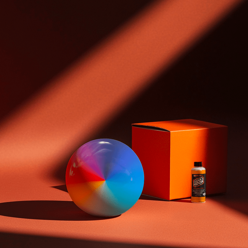 Hands holding a red orb with intricate, patterned artwork depicting a figure with sunglasses.