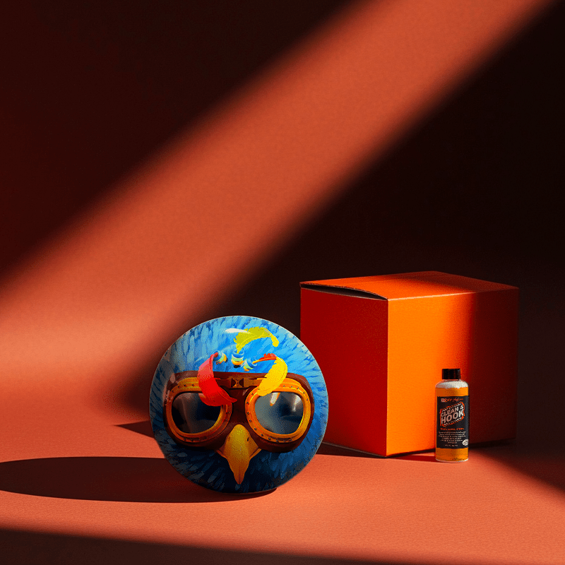 Hands holding a red orb with intricate, patterned artwork depicting a figure with sunglasses.