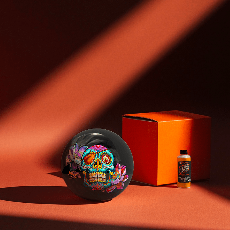 Hands holding a red orb with intricate, patterned artwork depicting a figure with sunglasses.