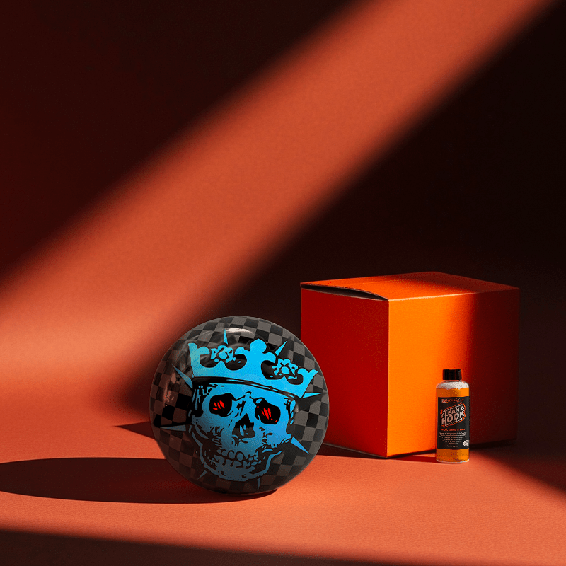 Hands holding a red orb with intricate, patterned artwork depicting a figure with sunglasses.