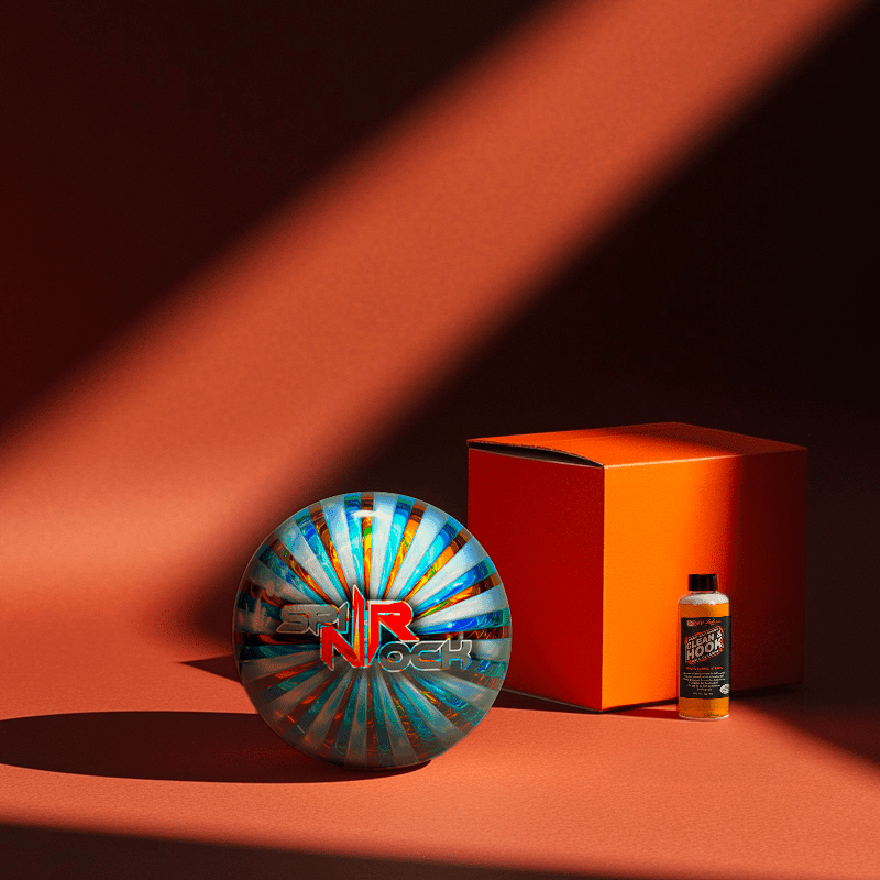 Hands holding a red orb with intricate, patterned artwork depicting a figure with sunglasses.