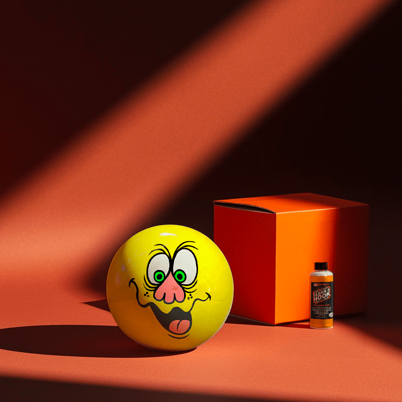 Hands holding a red orb with intricate, patterned artwork depicting a figure with sunglasses.