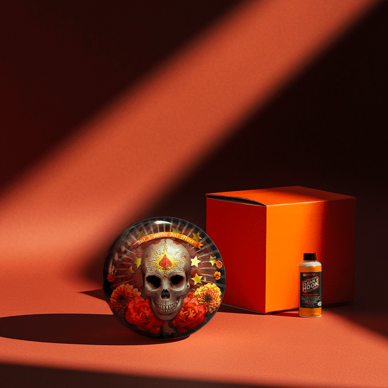 Hands holding a red orb with intricate, patterned artwork depicting a figure with sunglasses.