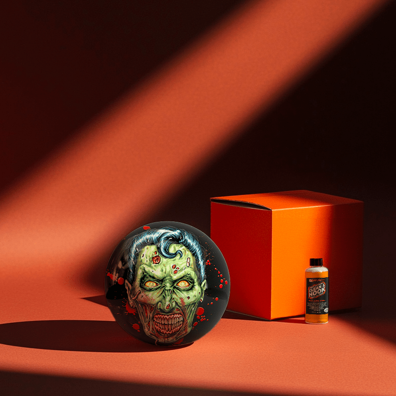 Hands holding a red orb with intricate, patterned artwork depicting a figure with sunglasses.