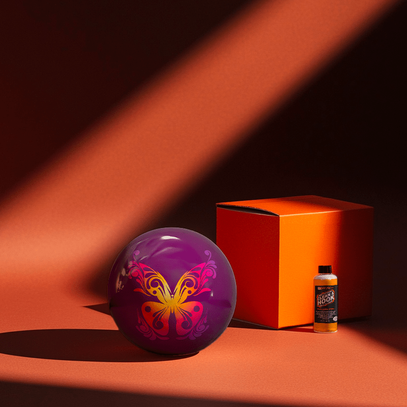 Hands holding a red orb with intricate, patterned artwork depicting a figure with sunglasses.