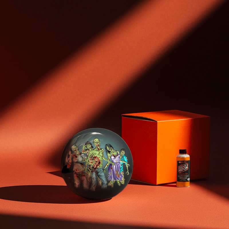 Hands holding a red orb with intricate, patterned artwork depicting a figure with sunglasses.