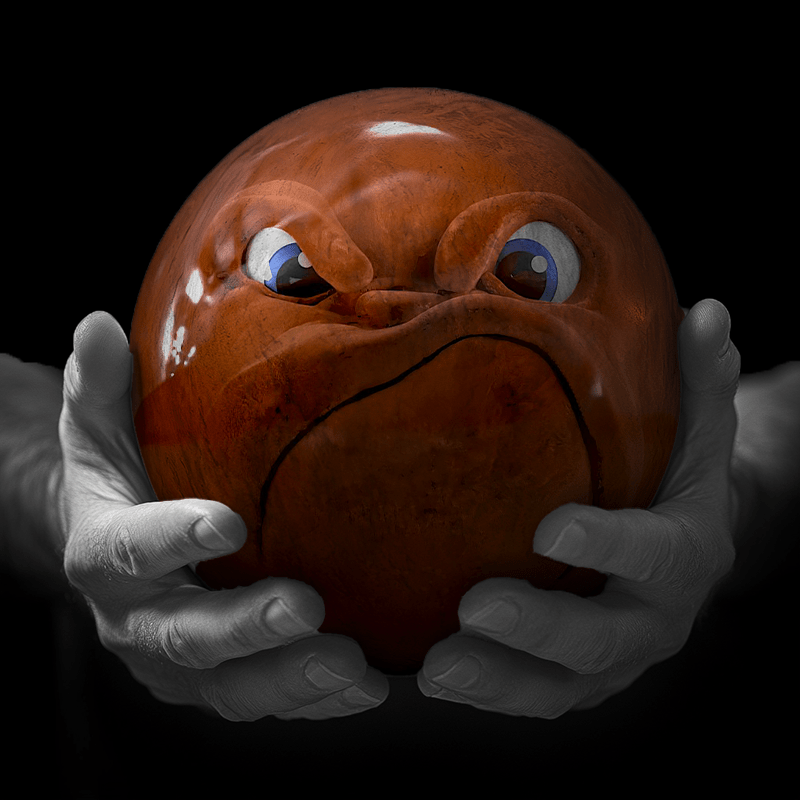 Hands holding a red sphere featuring a floral-patterned figure.