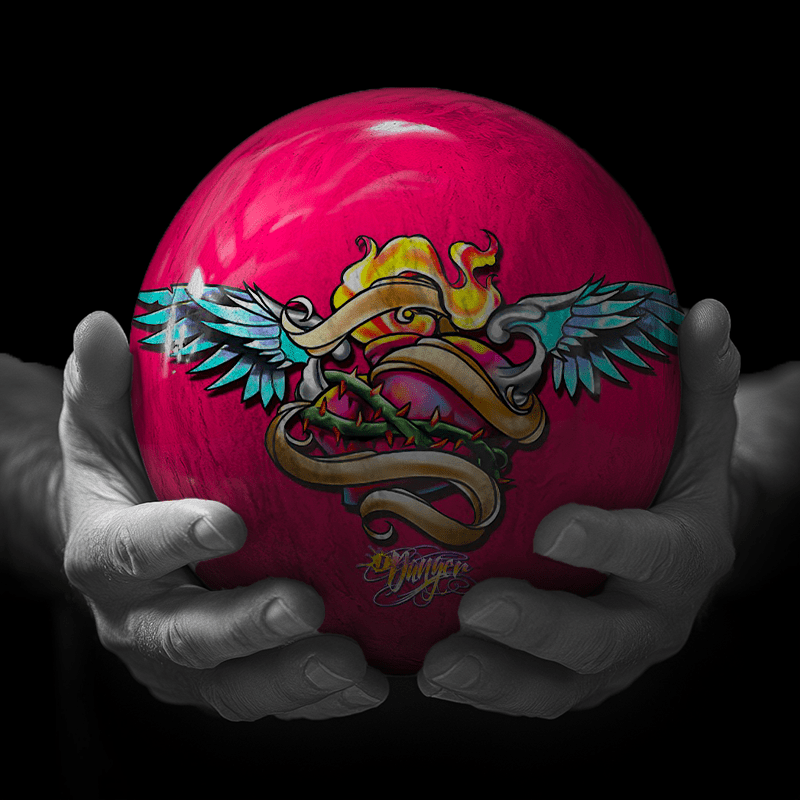 Hands holding a red sphere featuring a floral-patterned figure.