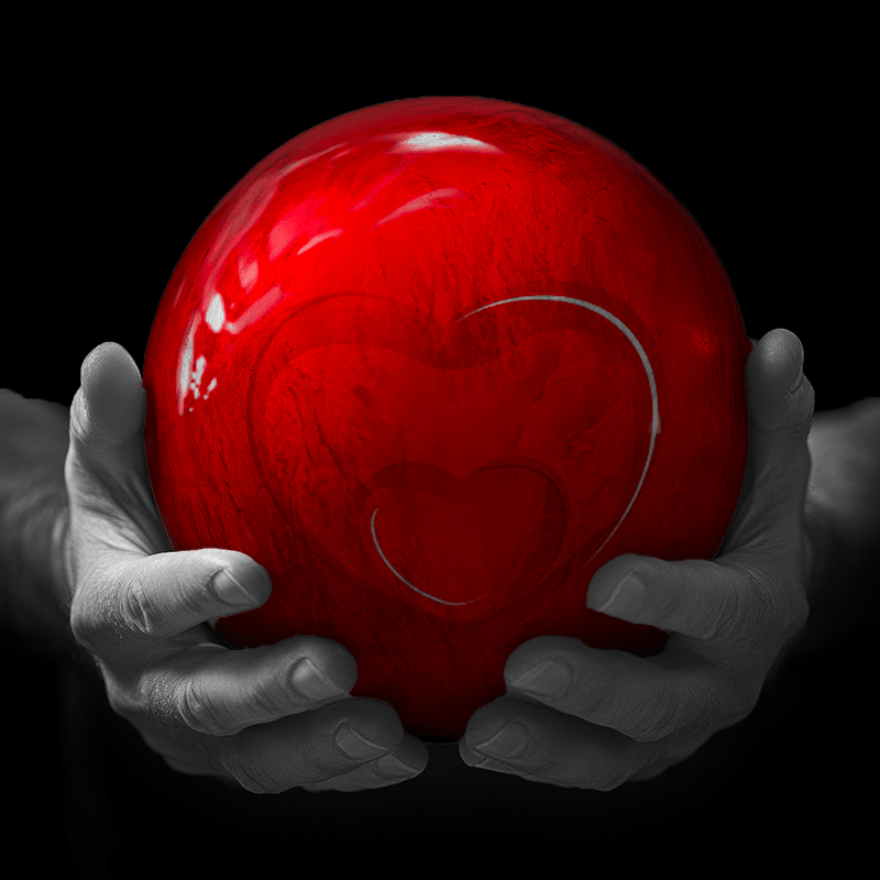 Hands holding a red sphere featuring a floral-patterned figure.