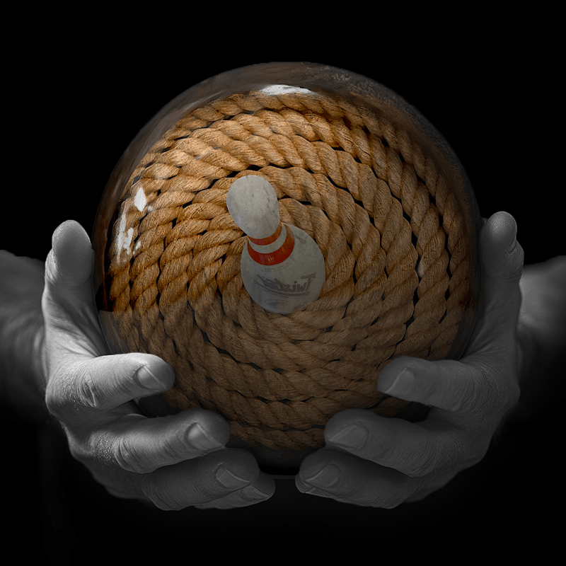 Hands holding a red sphere featuring a floral-patterned figure.