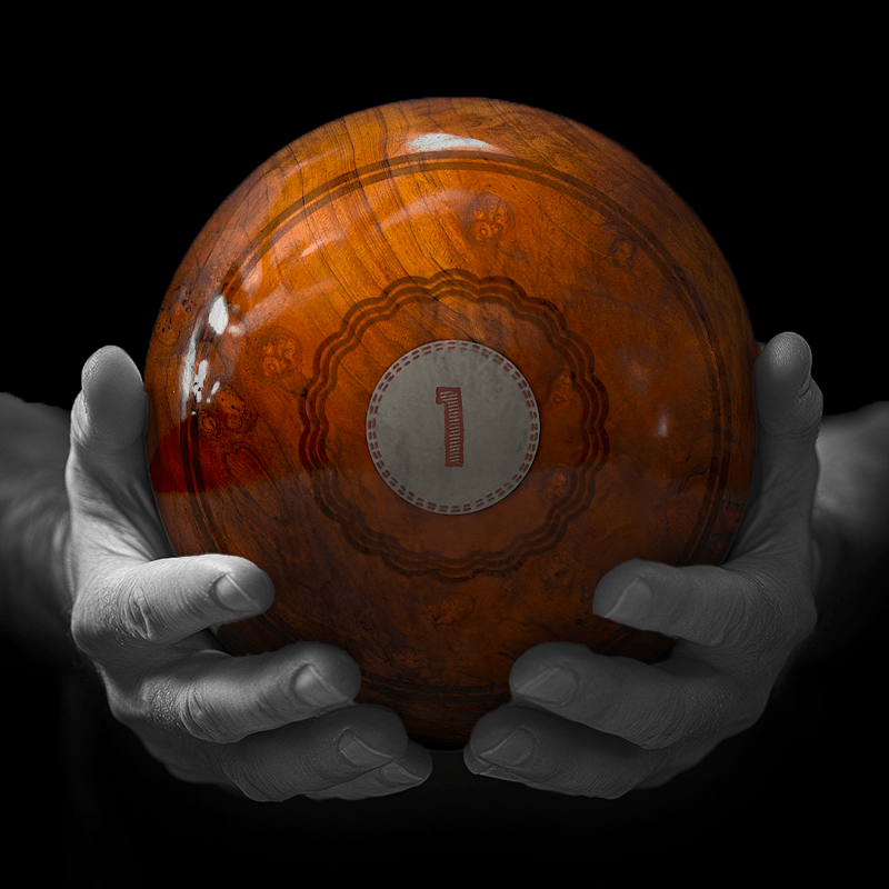 Hands holding a red sphere featuring a floral-patterned figure.