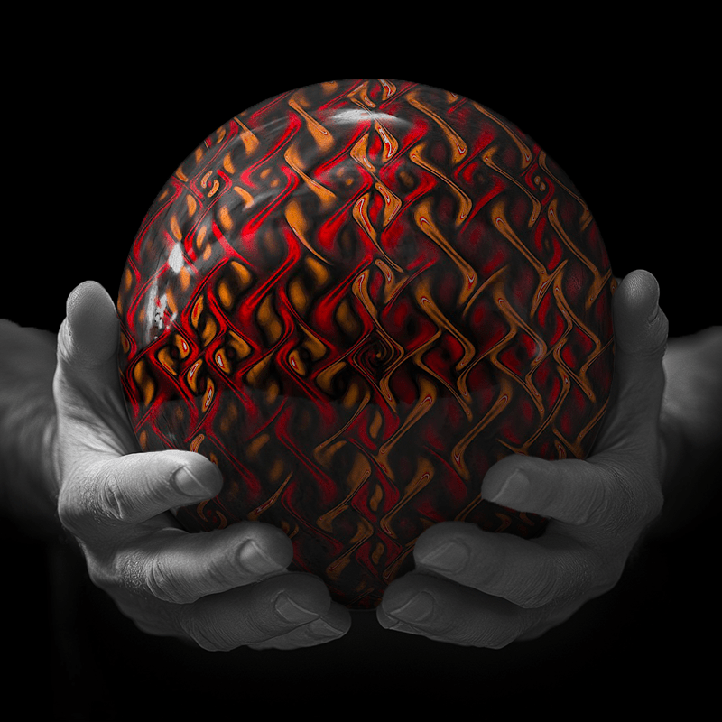 Hands holding a red sphere featuring a floral-patterned figure.